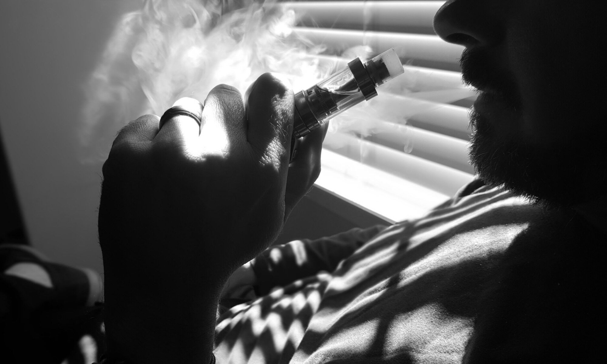 Mężczyzna palący e-papierosa w sypialni, Vaper City, 2016.